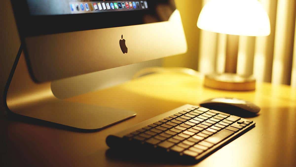 apple computer on desk with keyboard