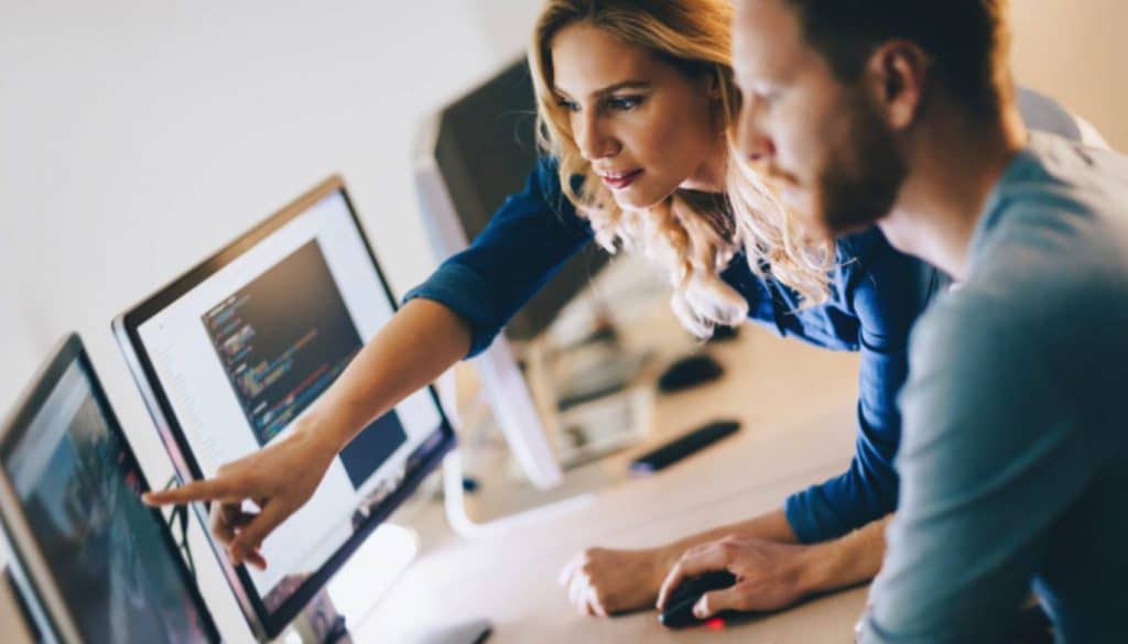 office software person leaning in helping someone code