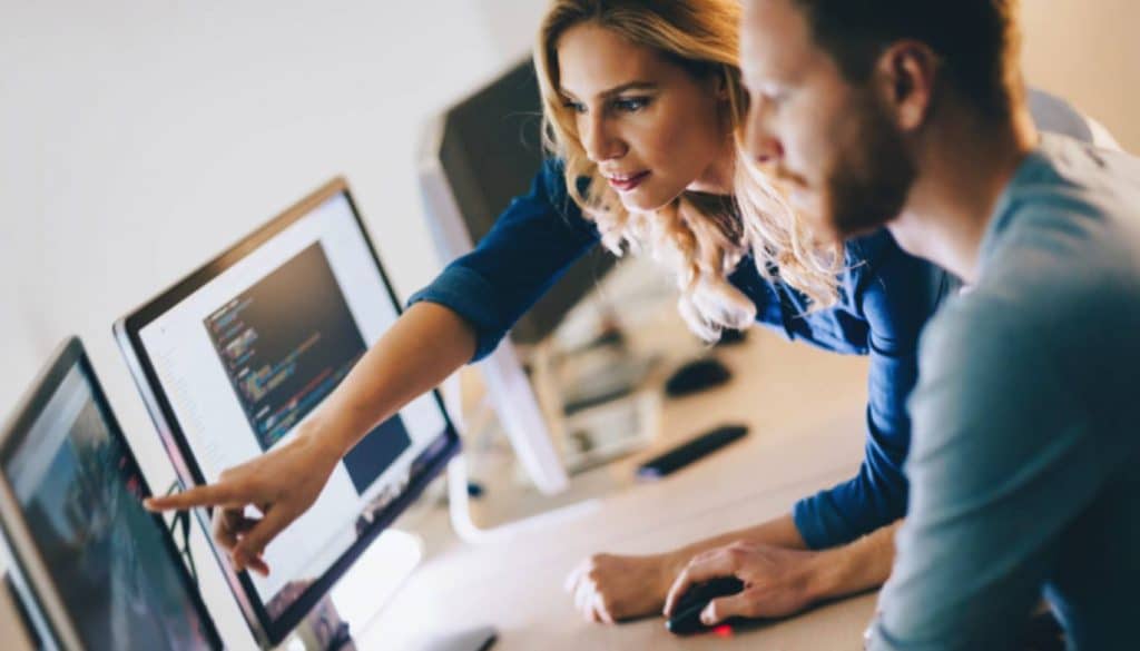 Office software person leaning in helping someone code