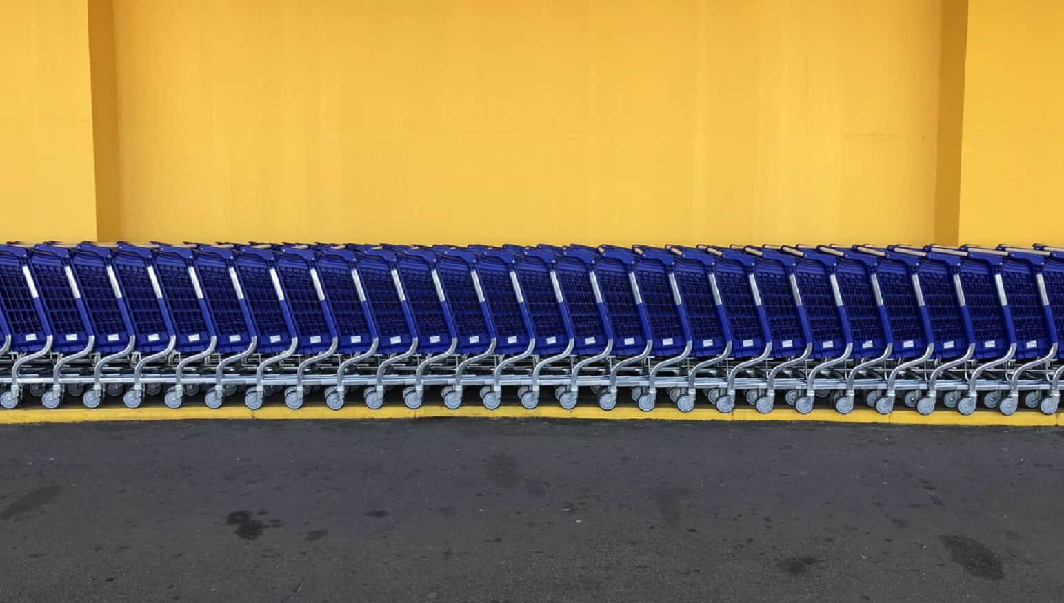 Walmart shopping carts against yellow wall