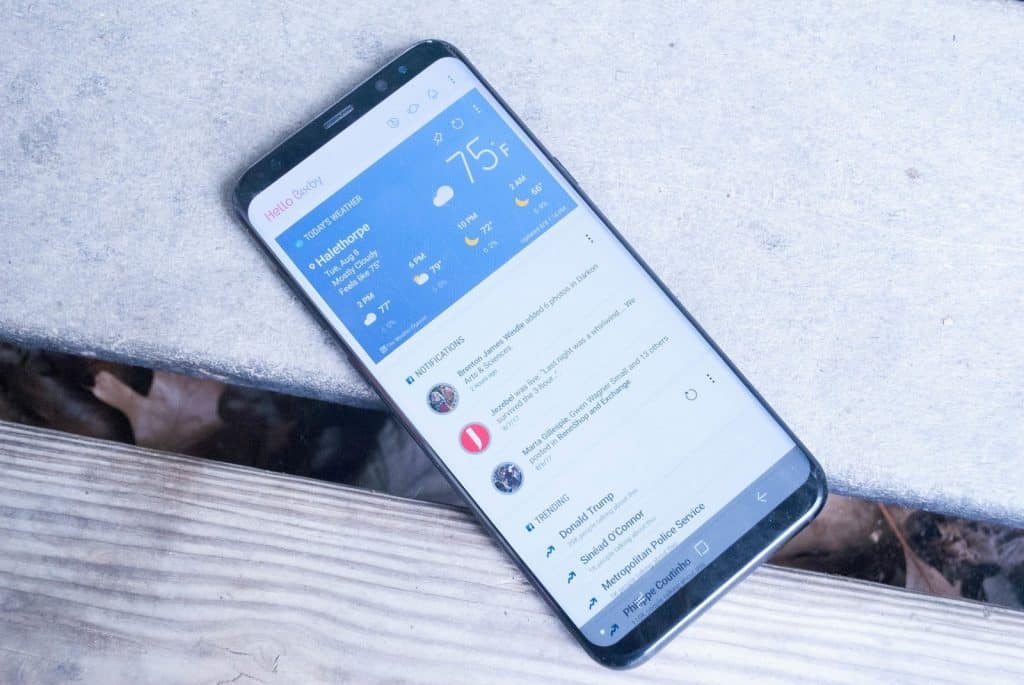 bixby home en un dispositivo galaxy s en un banco de madera