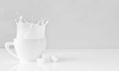 milk splashing out of a pitcher on a table