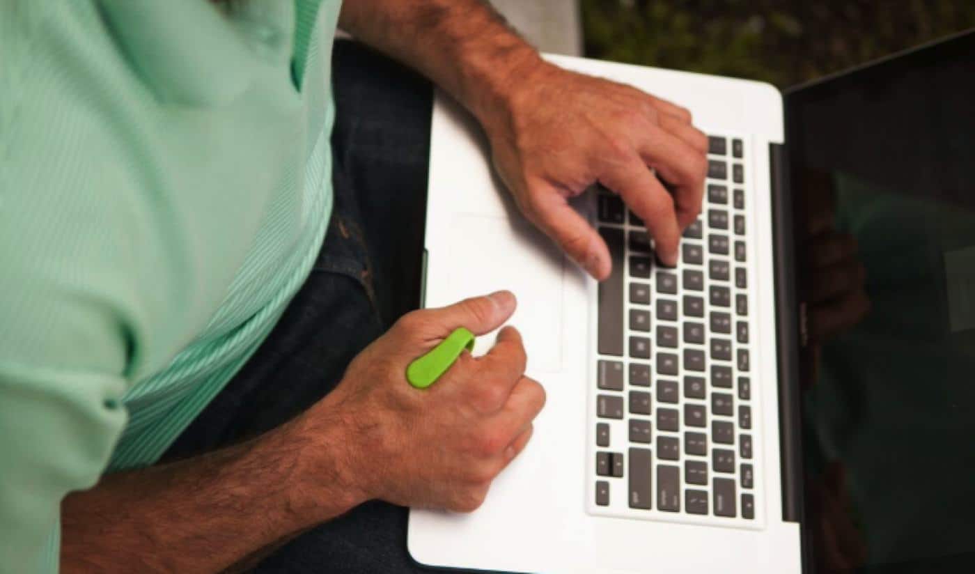 aculief wearable on man typing on laptop macbook pro