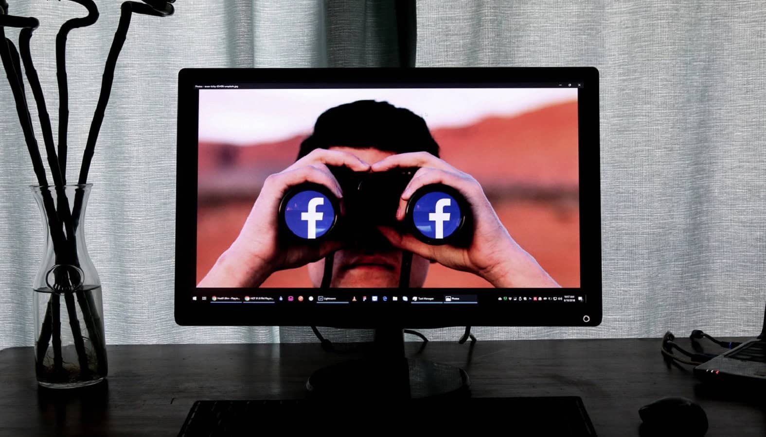 Facebook on computer with binoculars