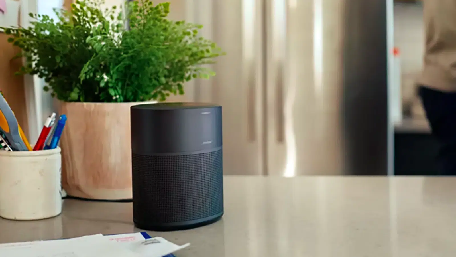 bose home 300 smart speaker on countertop with plants and letters