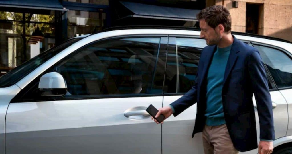 man standing next to bmw suv