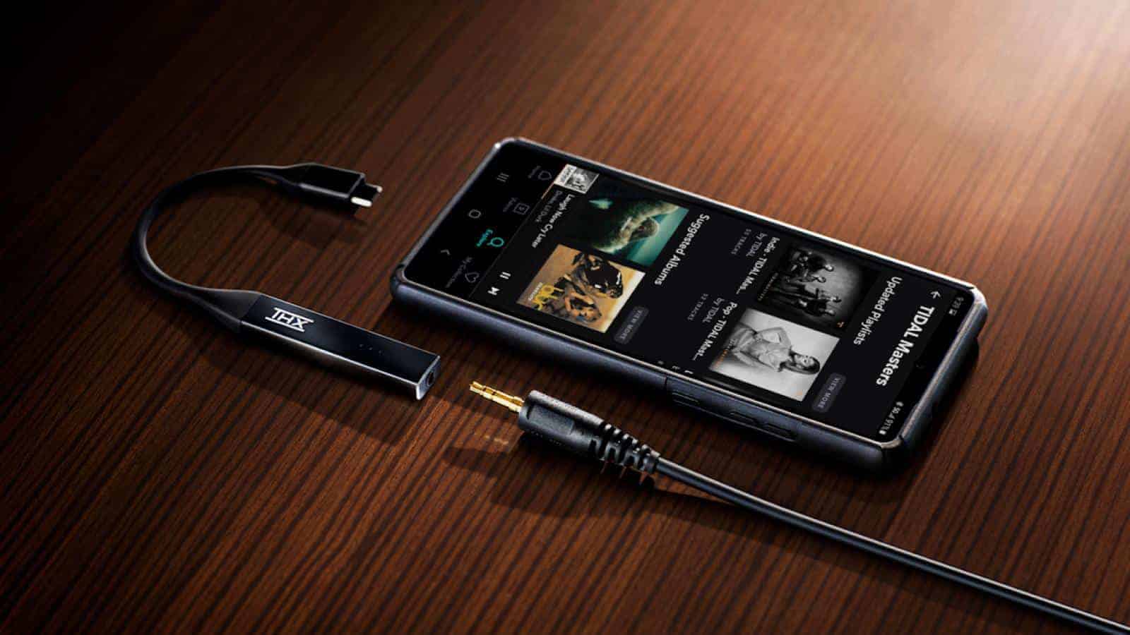 Thx onyx dac amp on table next to smartphone and headphone plug