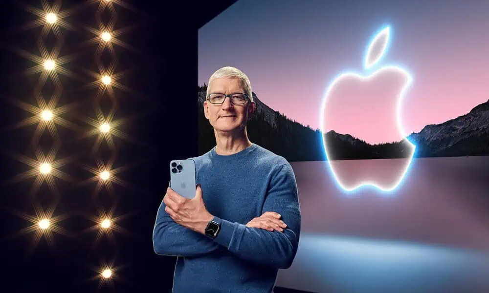 apple ceo tim cook standing on stage holding an iphone while wearing an apple watch