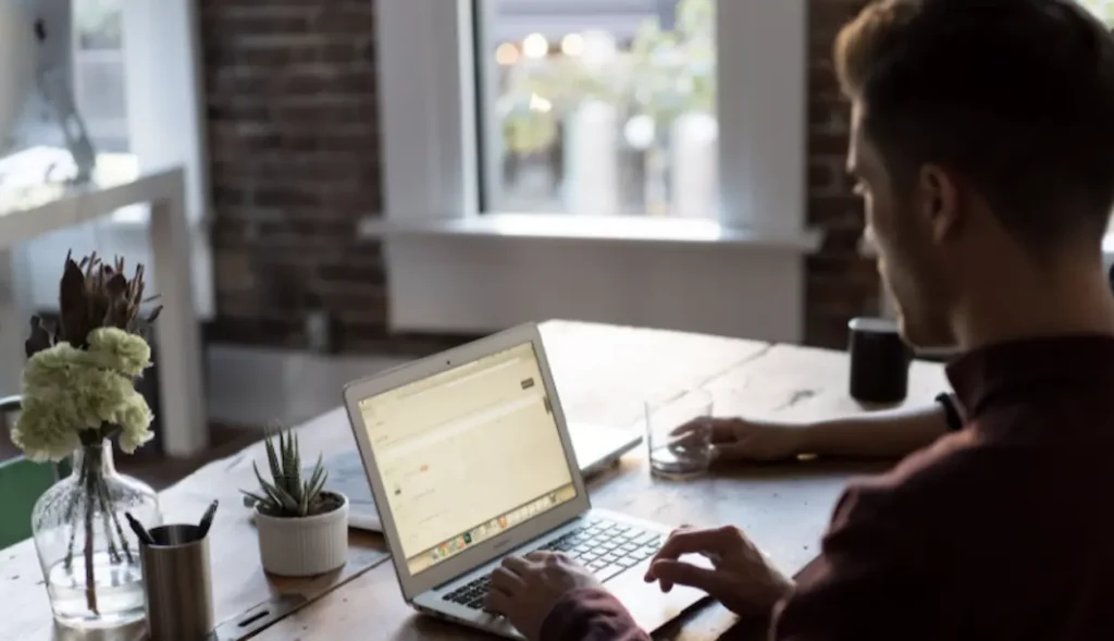 Man in home office typing on a laptop cms