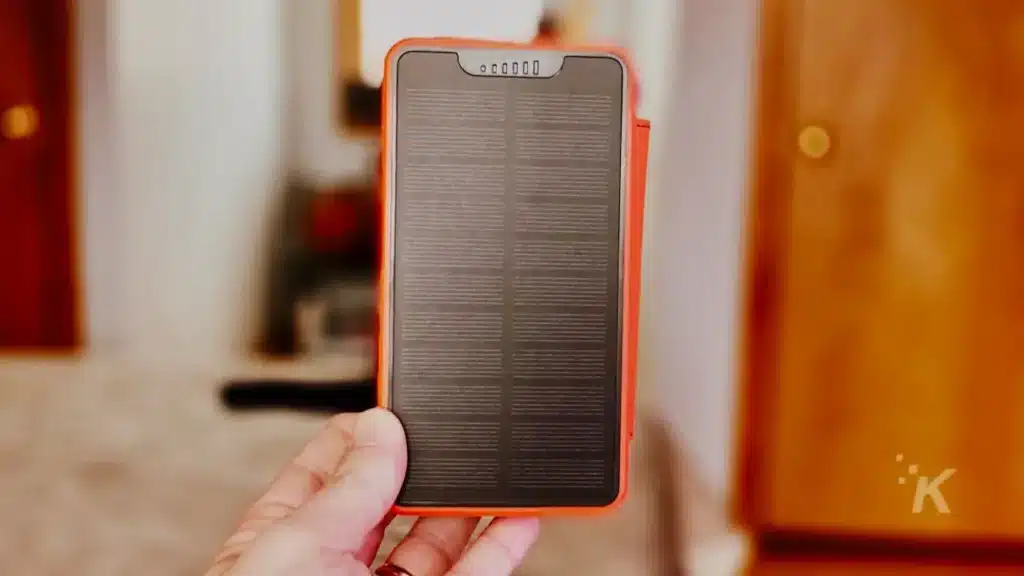 person holding a portable solar battery charger