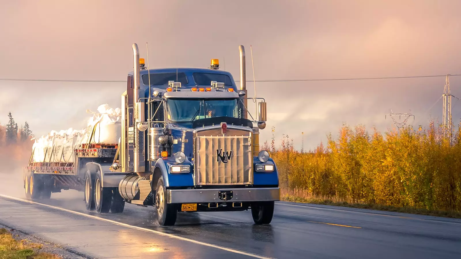 Semi truck transporting freight down a rainy path