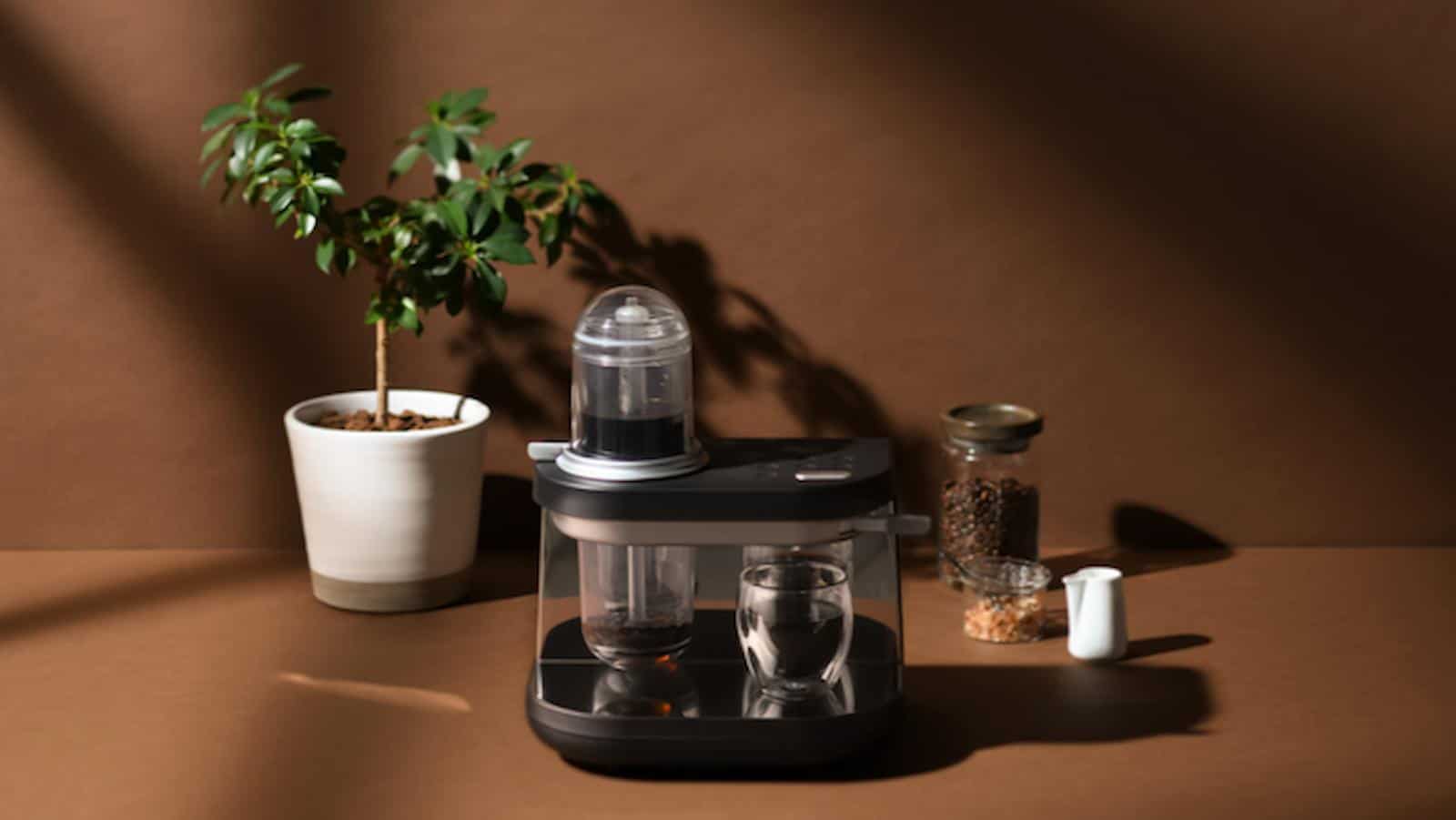 siphonysta automatic coffee maker on a table, surrounded by a plant and some mugs crowdfunding campaign