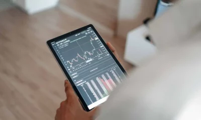 image of a person holding a tablet displaying a trading/investment/crypto app