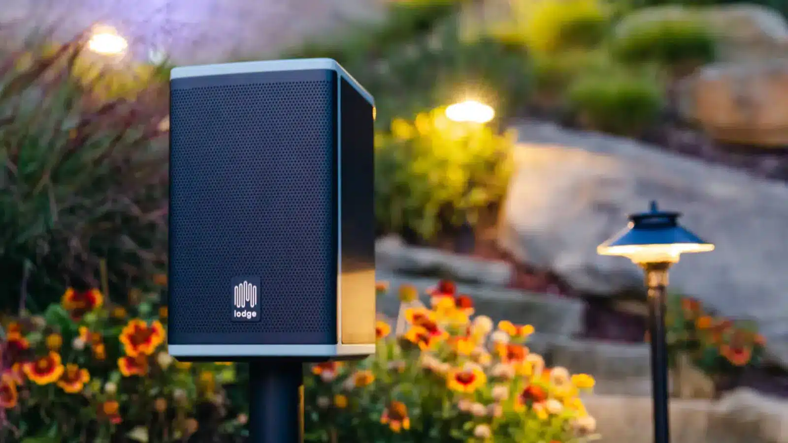 lodge solar outdoor speaker in a flowerbed