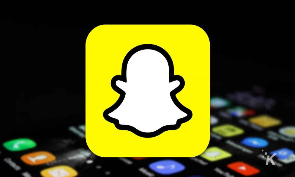 yellow snapchat logo with phone in the background