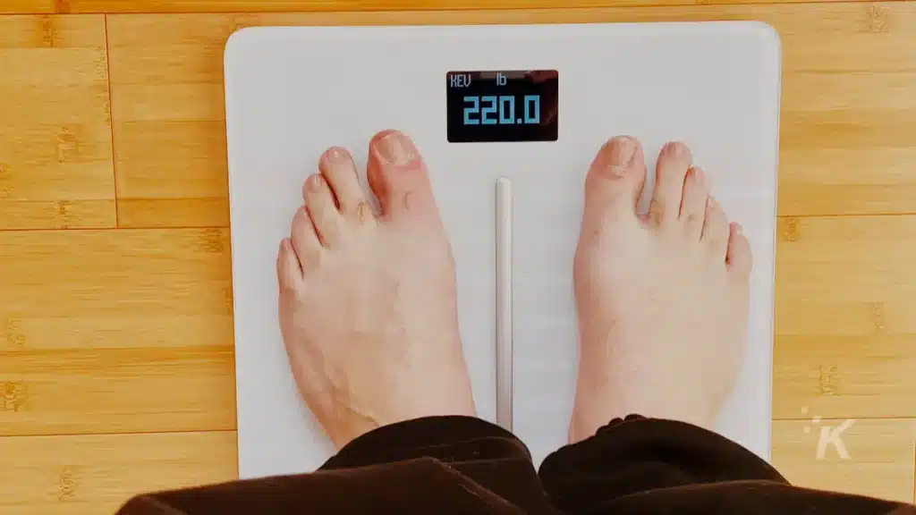 image of someone standing on a withings smart scale on hardwood floor