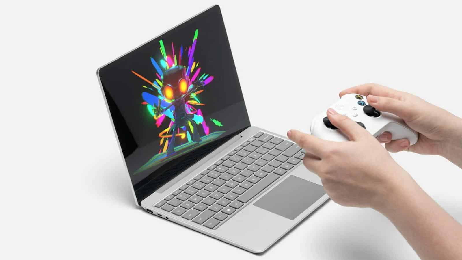 someone holding an xbox controller in front of the microsoft surface laptop go 2