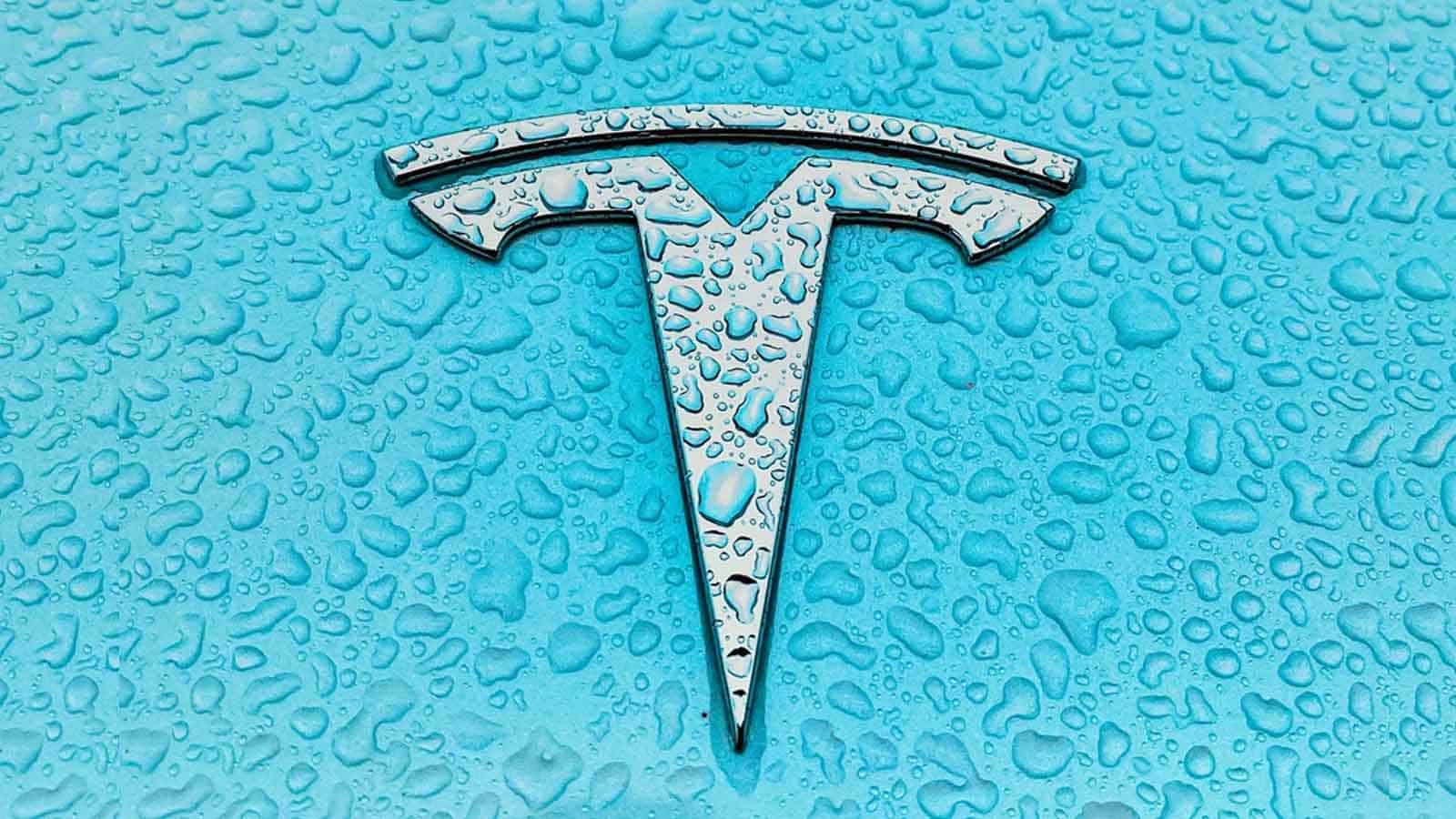 Tesla car emblem with water droplets