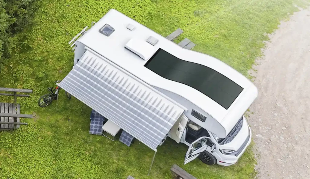 flexible solar panel on top of an RV parked on grass