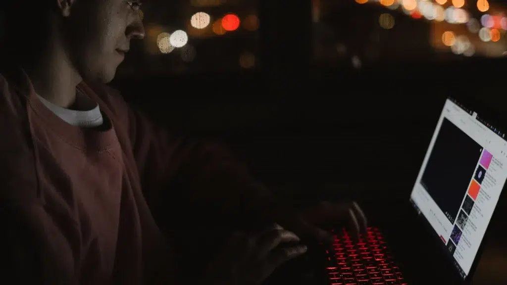 Person using laptop in the dark