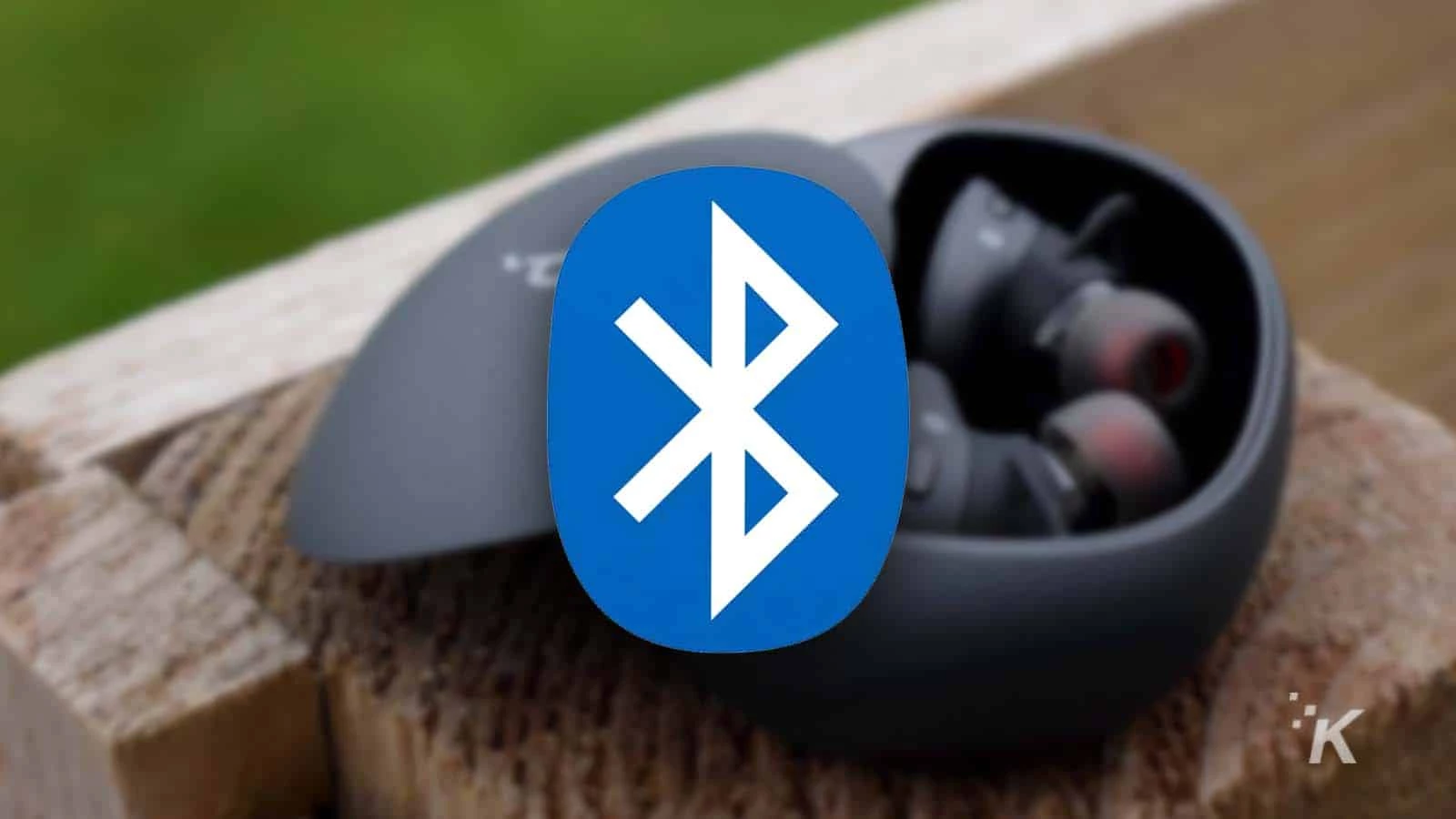 bluetooth logo with blurred earbuds in the background