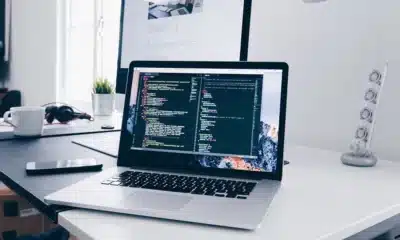 laptop on table with lines of code