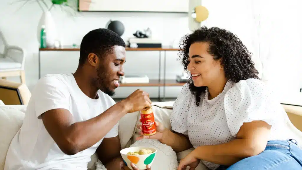 A couple eating on the couch