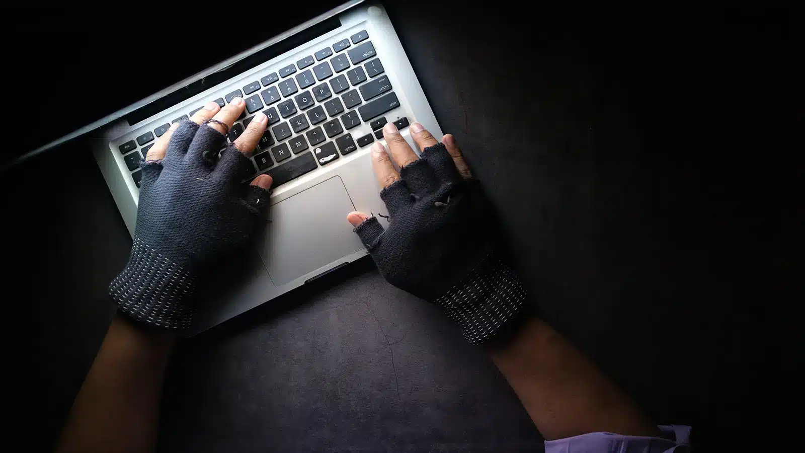 identity theft hands with gloves on laptop