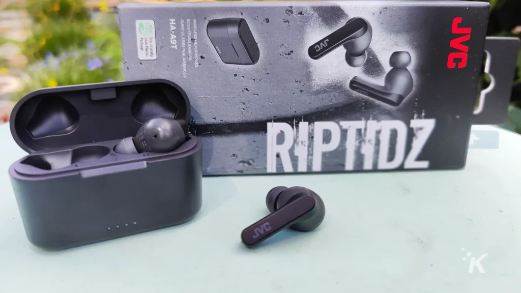 earbuds on table with packaging and charging case