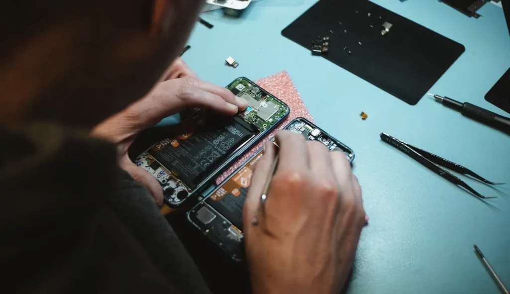 man repairing iphone via Apple's self-repair program