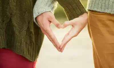 two people making a heart shape with hands