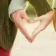 two people making a heart shape with hands