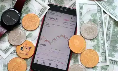 phone showing a chart and money coins bills