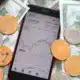 phone showing a chart and money coins bills