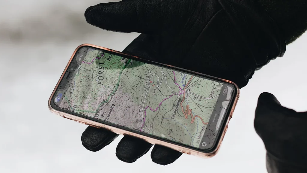 phone with map app open in a hand wearing a glove