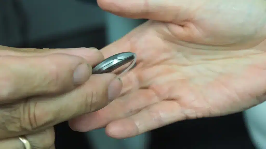 hand passing a hear aid to another