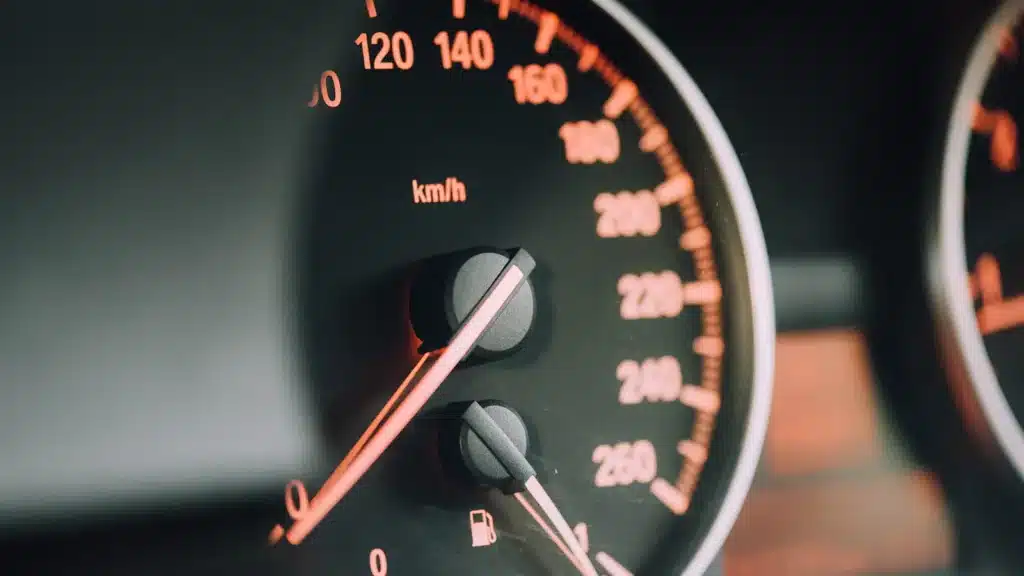 close up of speedometer in orange color gauges