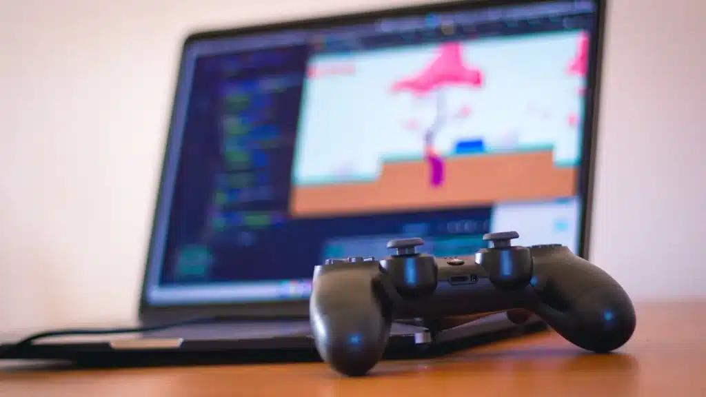 laptop on desk with a video game controller