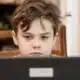 boy in front of a computer doing online tutoring
