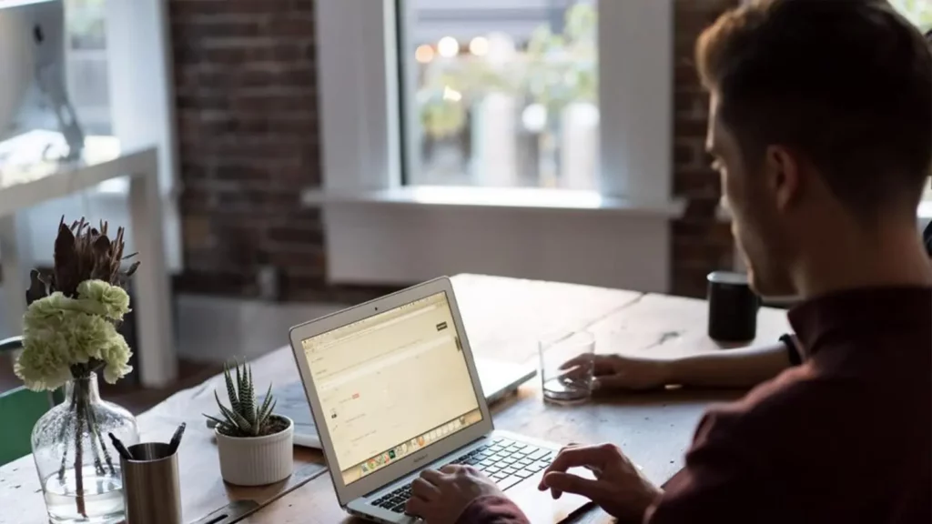 man emailing on laptop