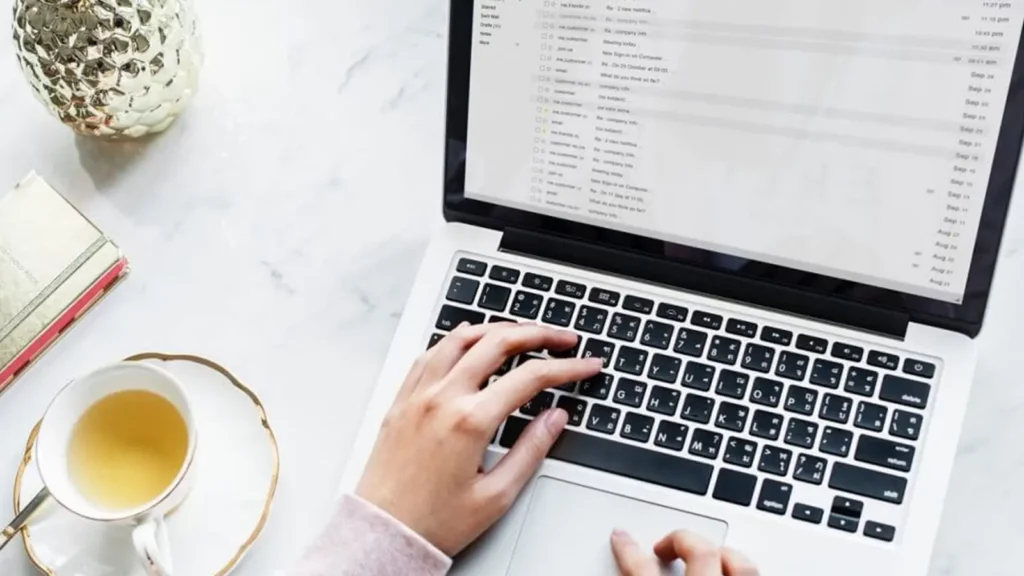 hands typing on laptop checking emails