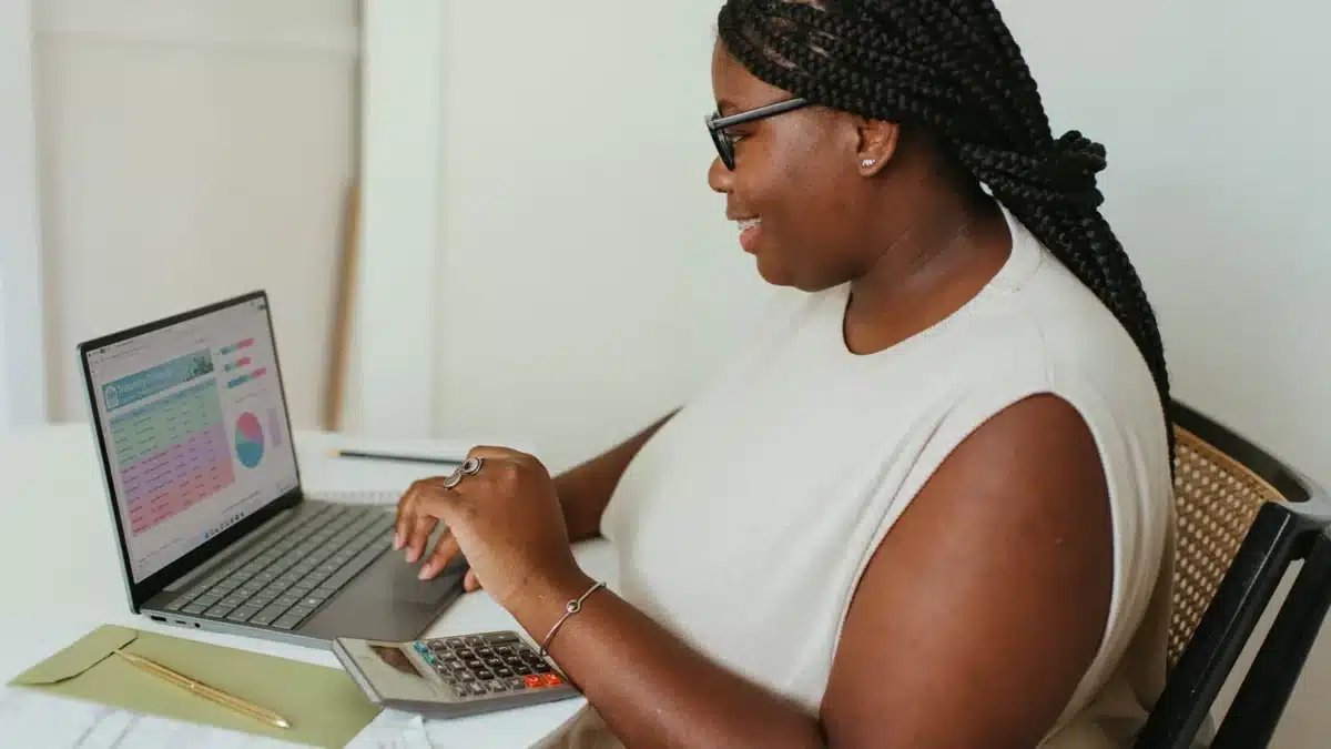 lady sitting in front of a laptop that displays graphs doing remote work