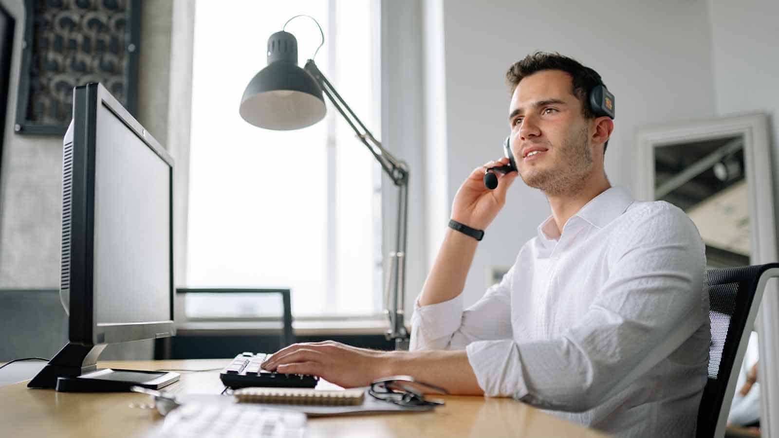 man at desk providing customer support over the phone