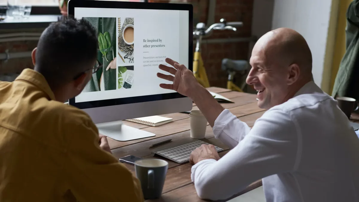two men walking in front of a computer screen partnership