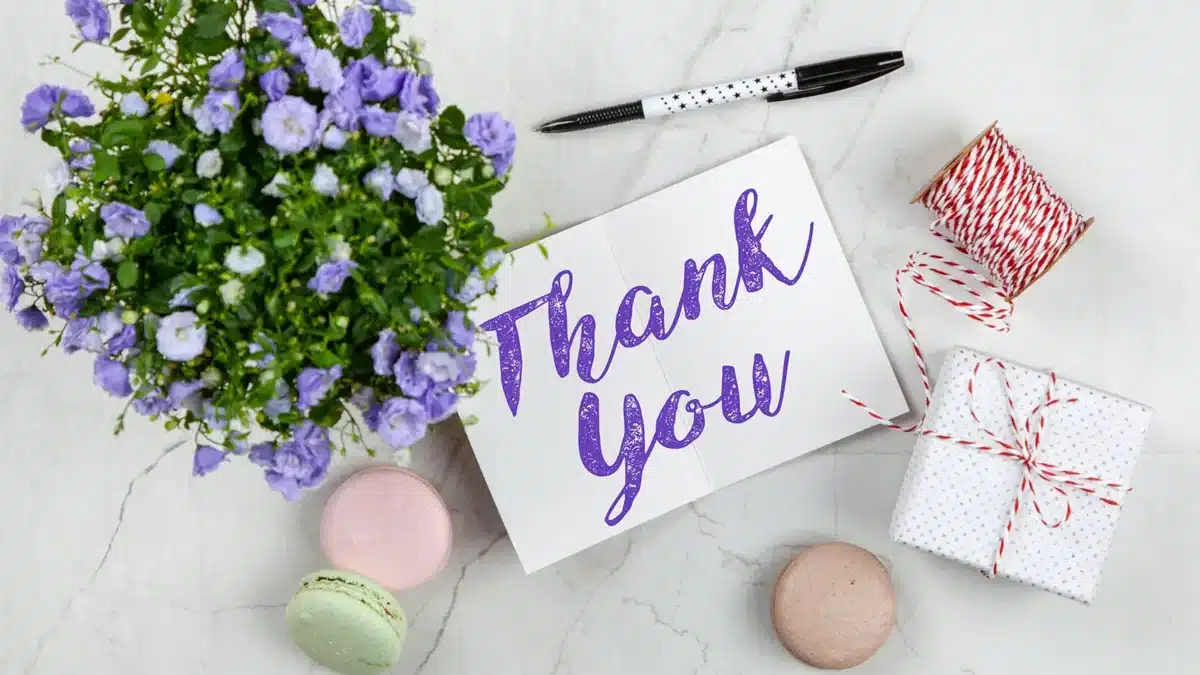 thank you card with flowers and cookies gifts on table