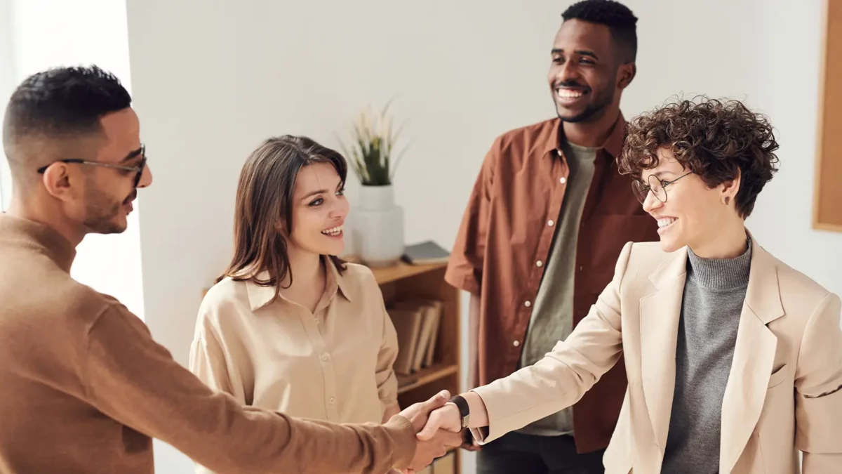 group of people in an office and two are shaking hands