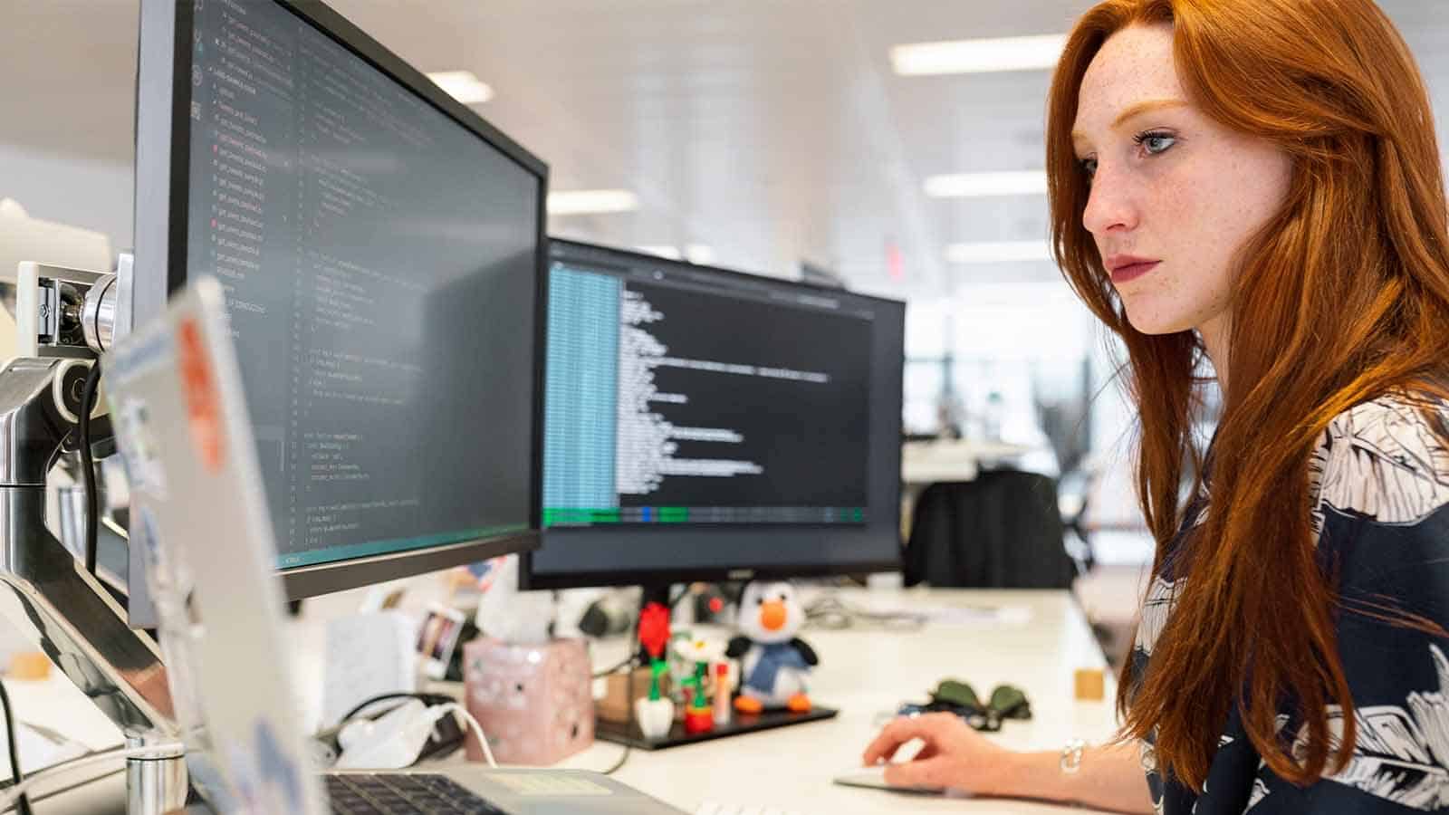 woman on looking at computer screens with cybersecurity