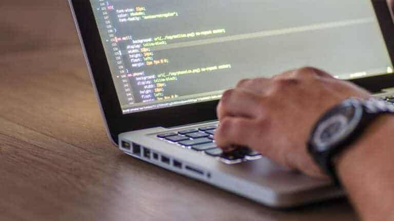person typing code on a laptop