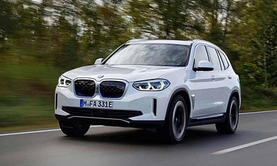 The white BMW iX3 suv electric is driving on the road.