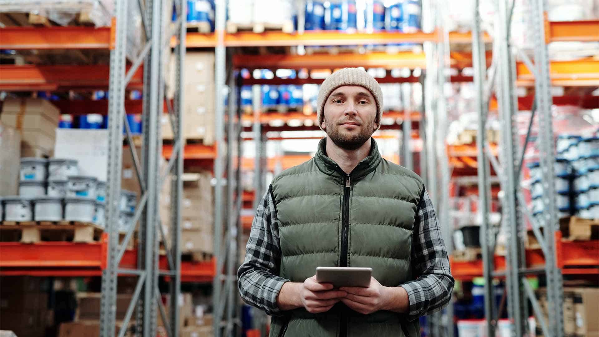 A person holds a phone in a warehouse.